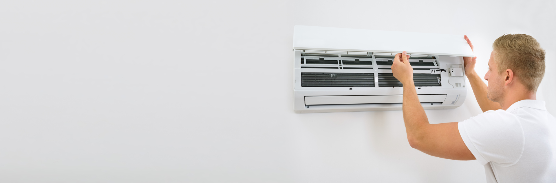 Hombre abre la tapa de una unidad de climatización